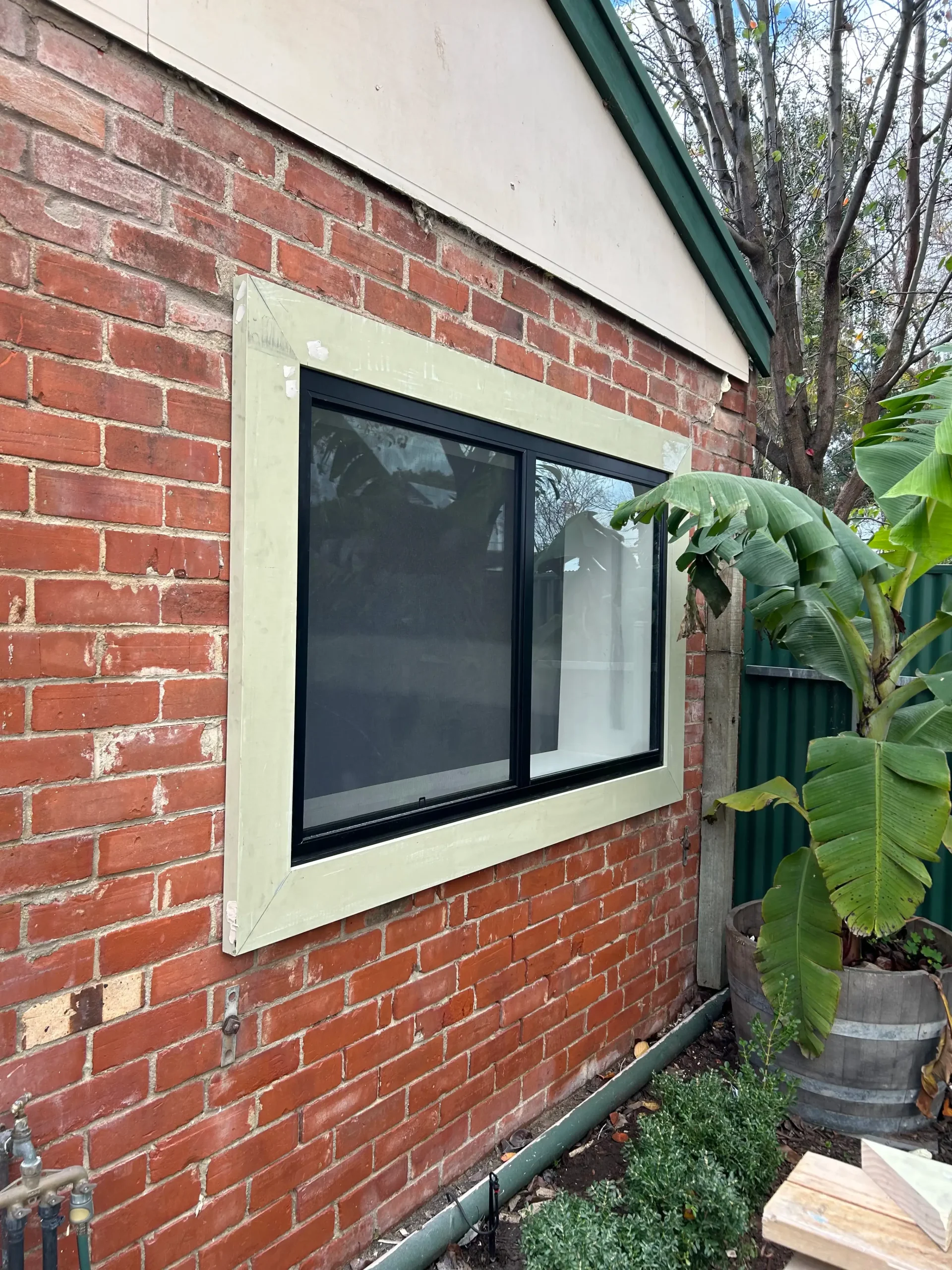New aluminium window cut into the brick wall of a garage being converted by Bella Carpentry