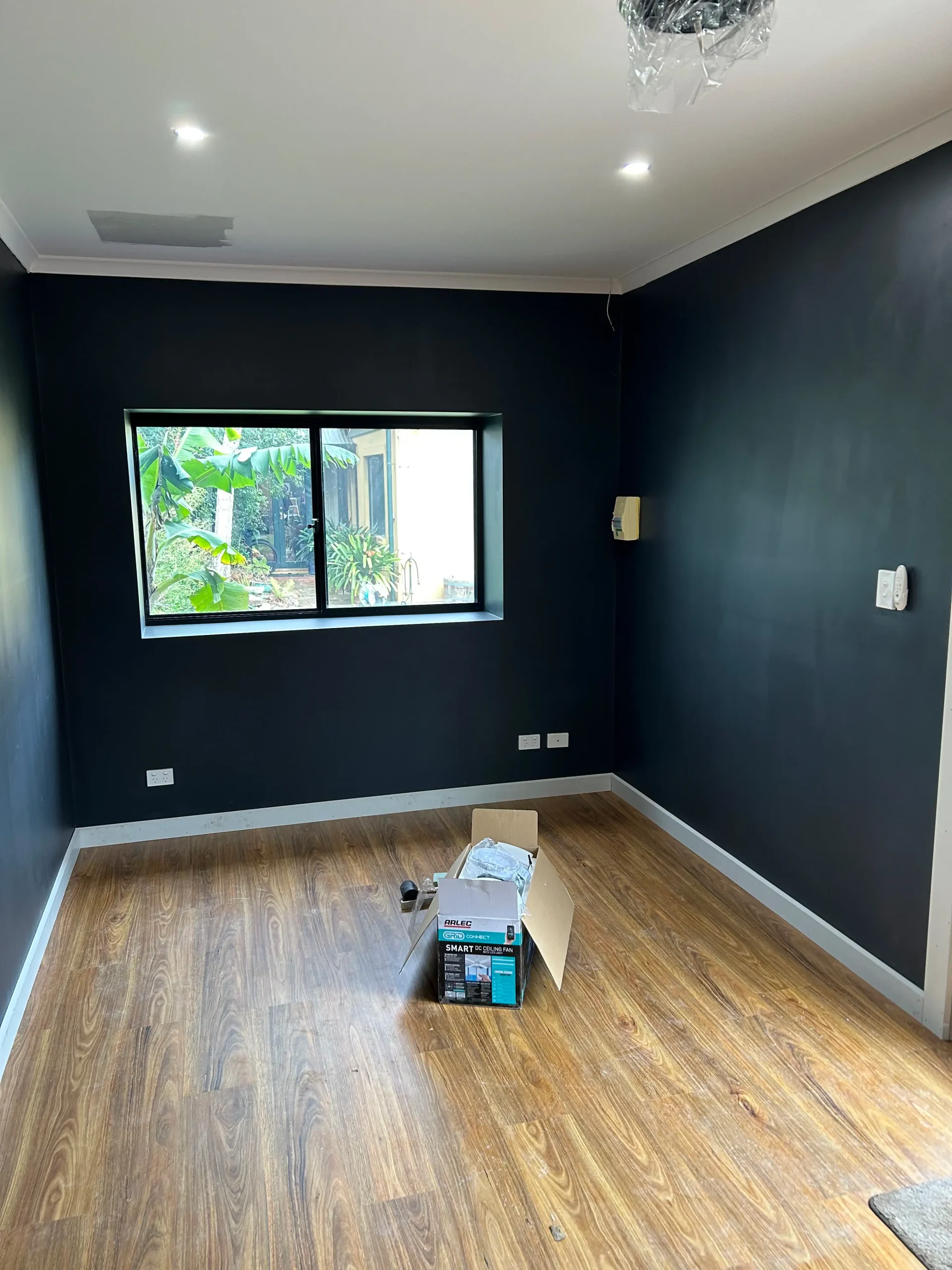 Finished garage conversion interior in Adelaide with new window, timber-look flooring and downlights